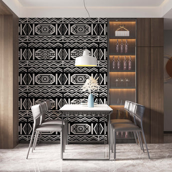 Ndebele inspired wallpaper geometric repeat pattern of zig zag lines and geometric shapes. Colours charcoal, grey, black and white. Setting is a table and chairs that complement the wallpaper.