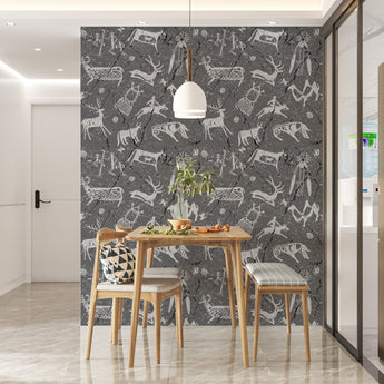 Wallpaper with  a charcoal background, and light grey, and black coloured graphics that look like cave Khoisan drawings. Setting is a table and chairs that complement the wallpaper.