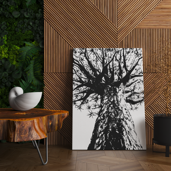 A large stylised print of a quiver tree. The tree is black in colour, resting on the floor against a wall consisting of brown wooden cladding .