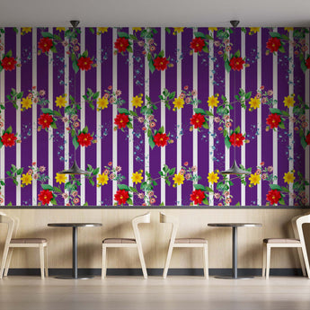 Coffee shop setting with chairs and tables. On the wall is a Tsonga inspired wallpaper. Wallpaper pattern of a colourful floral pattern of yellow flowers and red flowers with green leaves, on a background of purple and white vertical stripes.