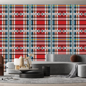 Venda inspired wallpaper with various geometric shapes. a geometric pattern of outlines of diamond shape and straight lines in various thicknesses. Background is red, with various thickness lines in grey, yellow, and blue colours. On a wall in a  living room setting.